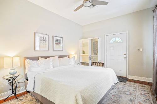 a white bedroom with a large bed and a ceiling fan at Eat Your Cake Too in New Orleans