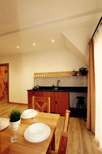 a kitchen with a wooden table with plates on it at KOŃSKA GÓRKA Agroturystyka in Rabka