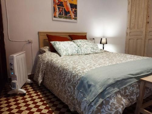 a bedroom with a bed and a checkered floor at Caserón Centenario in Cehegín