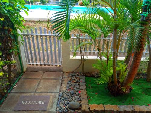 a garden with a palm tree and a fence at PRIM 29 in Flic-en-Flac