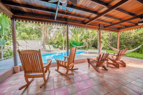 a patio with rocking chairs and a swimming pool at Azania Oasis in Puerto Viejo