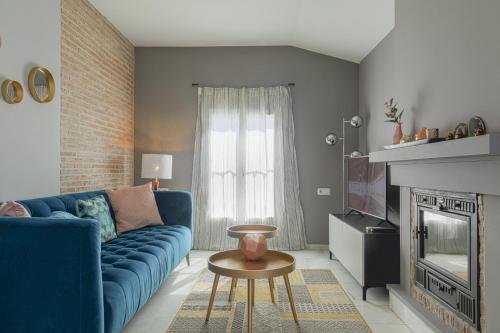 uma sala de estar com um sofá azul e uma lareira em Six Apartments by Caleta Homes em Málaga