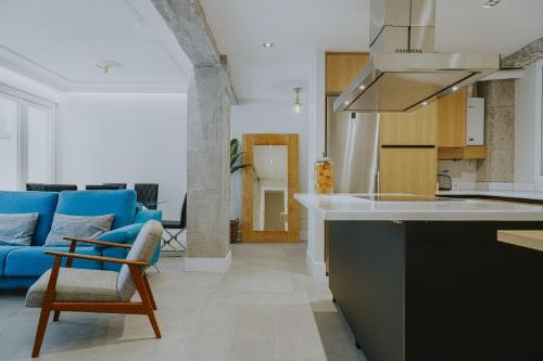 uma cozinha e sala de estar com um sofá azul em Six Apartments by Caleta Homes em Málaga