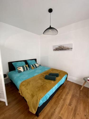 a bedroom with a large bed with a blue comforter at Ty Matelot by Póm - Proche centre-ville in Lorient