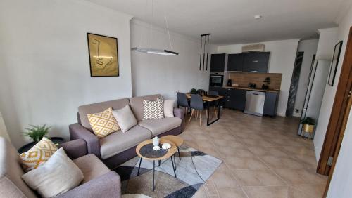 a living room with a couch and a table at Eve Santa Marina Apartments - sea, pools, relax in Sozopol