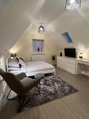 a bedroom with a bed and a chair and a television at 8 Studio, cosy loft, 50m to Airbus, bus-stop 20m, in Bristol