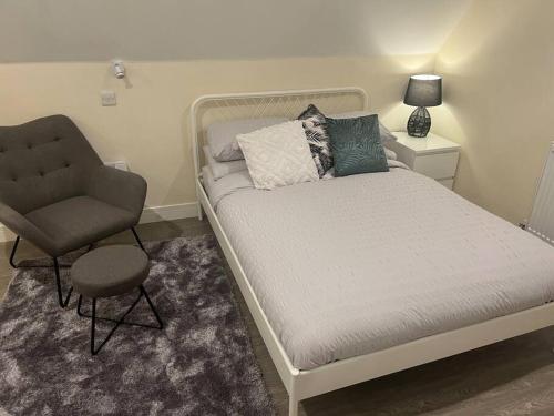 a bed and a chair in a small room at 8 Studio, cosy loft, 50m to Airbus, bus-stop 20m, in Bristol