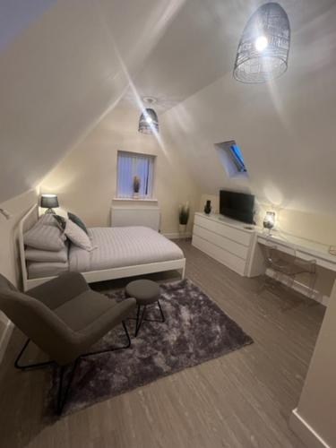 a bedroom with a bed and a chair and a television at 8 Studio, cosy loft, 50m to Airbus, bus-stop 20m, in Bristol