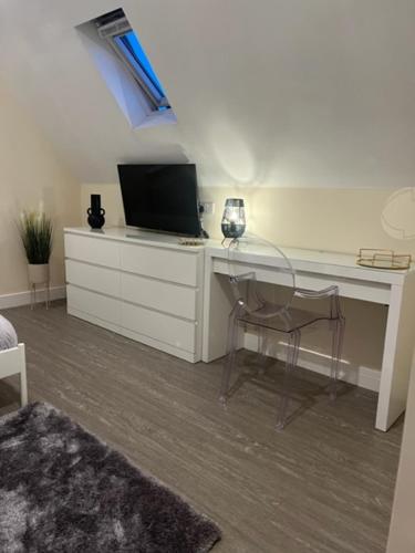 a white desk with a television and a chair at 8 Studio, cosy loft, 50m to Airbus, bus-stop 20m, in Bristol