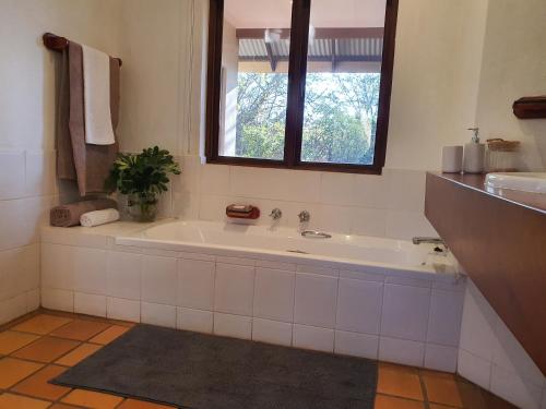 a bathroom with a bath tub and a window at Heuglins Lodge in White River