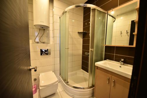 uma casa de banho com um chuveiro, um WC e um lavatório. em ORBI BATUMi SEA VIEW em Batumi