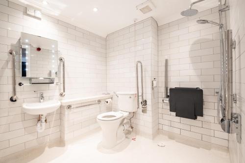 La salle de bains blanche est pourvue de toilettes et d'un lavabo. dans l'établissement Miller & Carter Sheffield by Innkeeper's Collection, à Sheffield