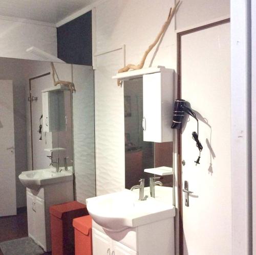 a bathroom with two sinks and two mirrors at Studio confortable Le Port 24 m² avec piscine partagée in La Possession