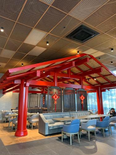 a restaurant with red columns and tables and chairs at Wanda Vista Istanbul in Istanbul