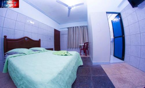 um quarto com uma cama com um edredão verde em RESIDENCIAL FRANCIA em Santa Cruz de la Sierra