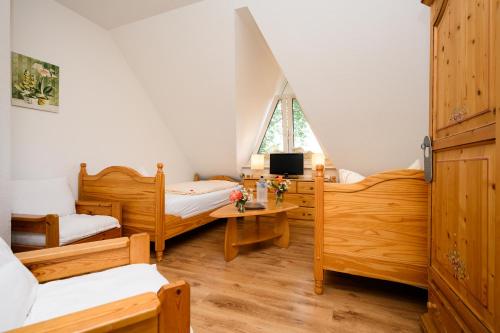 a room with two beds and a tv in it at Landhaus Nienhagen in Ostseebad Nienhagen