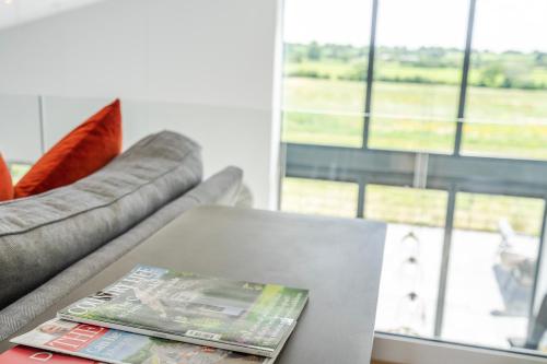a magazine sitting on a table next to a couch at The Grove - Converted Cattle Barn in Malmesbury