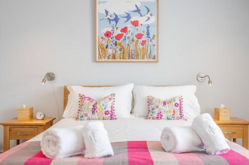 a bedroom with a bed with white blankets and pillows at The Grove - Converted Cattle Barn in Malmesbury