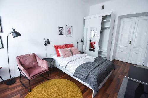 a bedroom with a bed and a chair at LION apartments - LaBA in Krakow