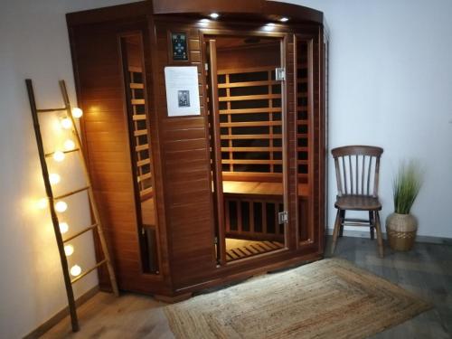 a room with a wooden closet with a chair at Gîtes Famille En Othe in Bouilly