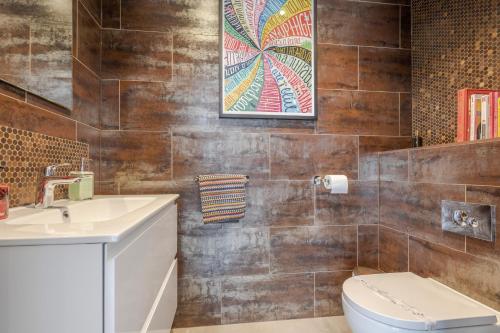 a bathroom with a toilet and a sink at The Grove - Converted Cattle Barn in Malmesbury