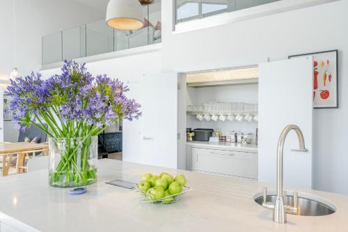 a kitchen with a vase of purple flowers on a counter at The Grove - Converted Cattle Barn in Malmesbury