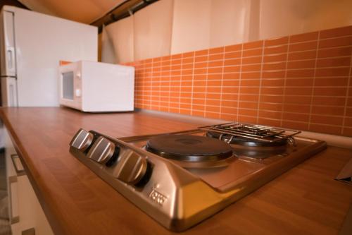 a stove top in a kitchen with a microwave at Camping Cambrils Caban in Cambrils
