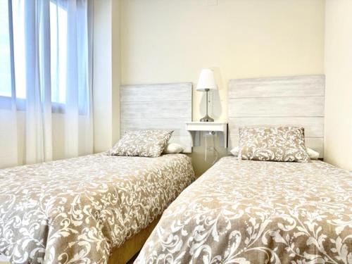 Duas camas sentadas uma ao lado da outra num quarto em Apartamento Puerta Cerrada em Écija