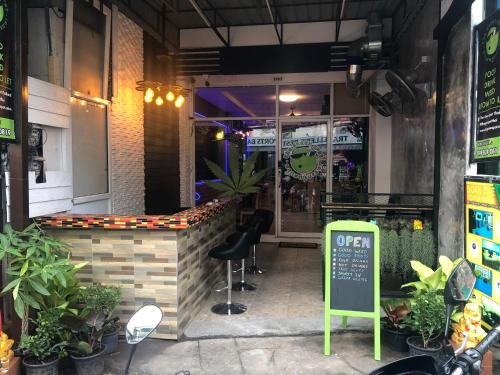 a restaurant with a green sign in front of it at Bonkers Guesthouse in Pattaya Central