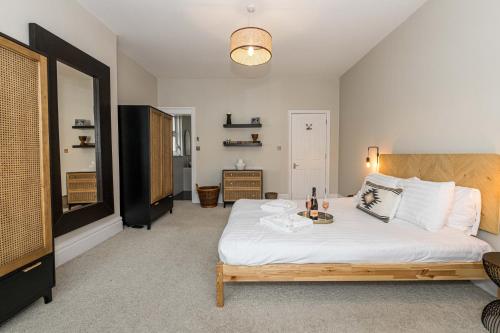 1 dormitorio con 1 cama grande con sábanas blancas en 1 Min to Beach, 8 Guests, Garden, Snug, Parking - Azure House en Bournemouth