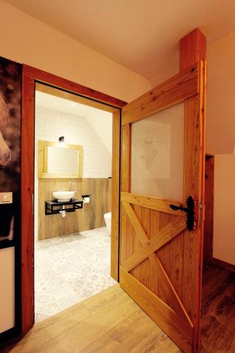 a bathroom with a wooden door and a sink at KOŃSKA GÓRKA Agroturystyka in Rabka