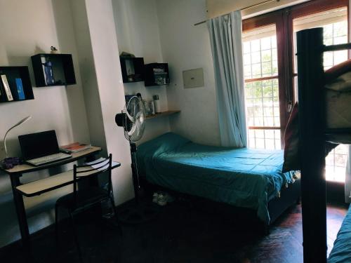 um quarto com uma cama, uma secretária e uma janela em HA! 2 Resi para estudiantes em Córdoba