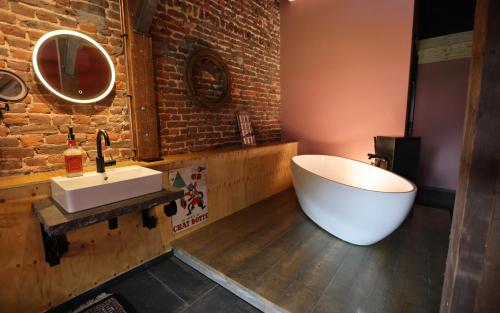 a bathroom with a white tub and a sink at VET - Bed & Breakfast in Beek