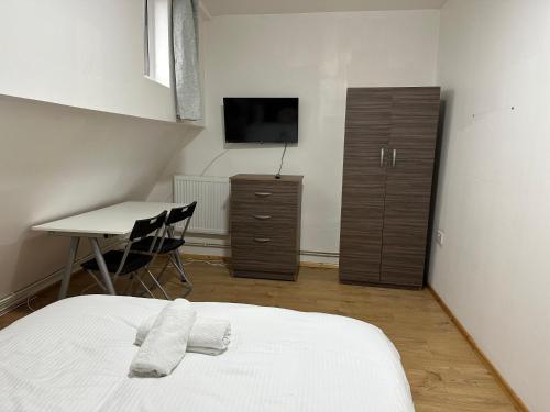 Dormitorio con cama, escritorio y TV en City Lodge Shadwell en Londres