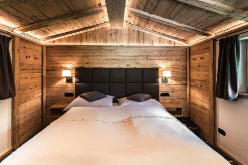 a bedroom with a large bed in a wooden room at Bärenbach - Almhütte Saalbach in Saalbach Hinterglemm