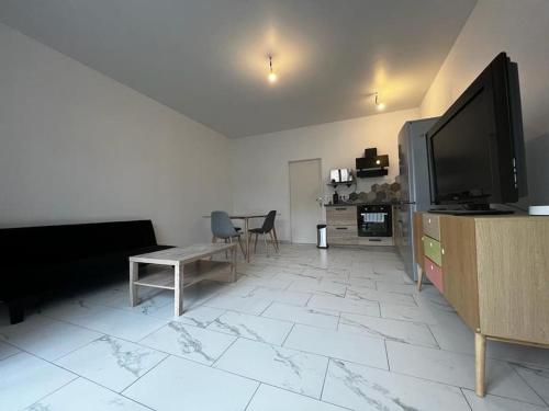 sala de estar con TV de pantalla plana y mesa en Bel appartement en centre ville de Limoges en Limoges