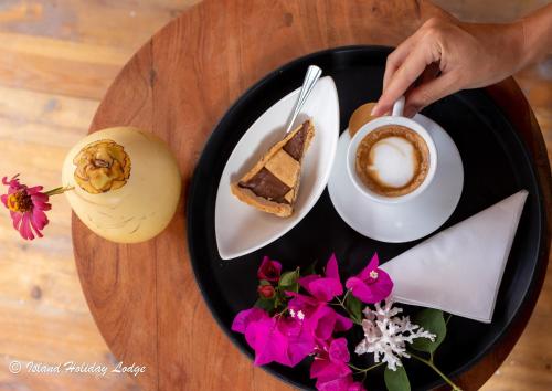 a table with a plate of food and a cup of coffee at Island Holiday Lodge in Felidhoo 