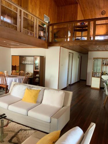 a living room with a white couch and wooden floors at Villa Eden Wood in Ivato