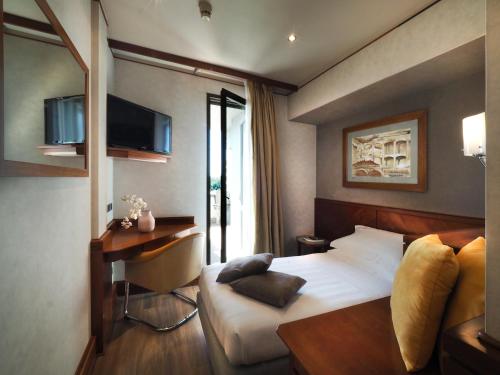 sypialnia z łóżkiem, biurkiem i telewizorem w obiekcie Perugia Park Hotel w mieście Perugia