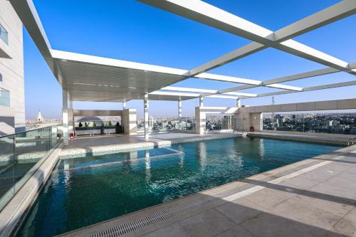 a swimming pool on the roof of a building at Abdali Views Apartments in Amman