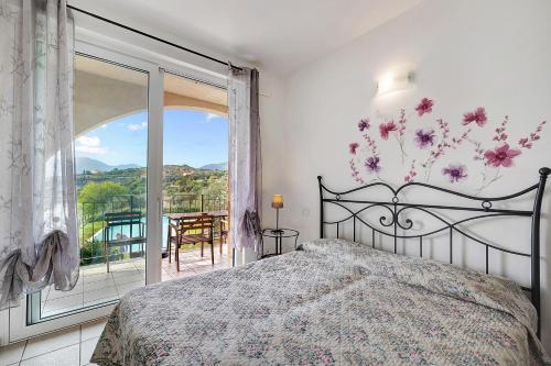 a bedroom with a bed and a large window at Appartamento Camelia in Pietra Ligure