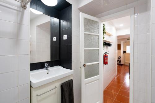 een badkamer met een wastafel en een spiegel bij Alfama Nest in Lissabon