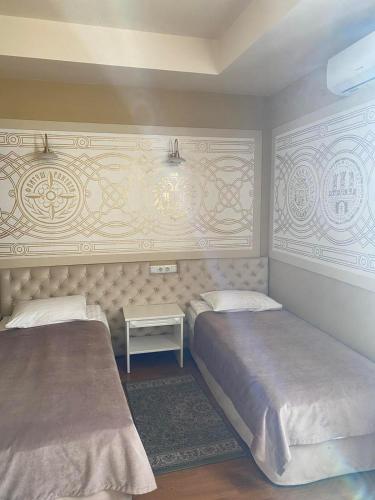 a bedroom with two beds and a side table at Fontush Boutique Hotel in Ivano-Frankivsʼk