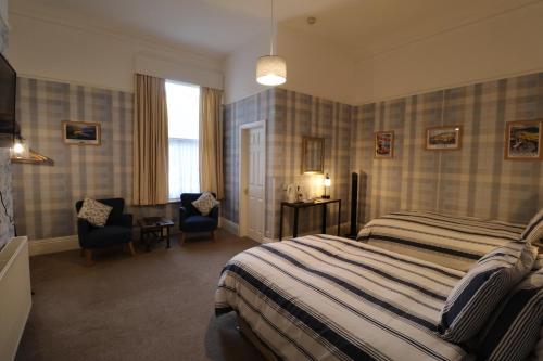 um quarto de hotel com uma cama, uma secretária e uma cadeira em The Raincliffe Hotel em Scarborough