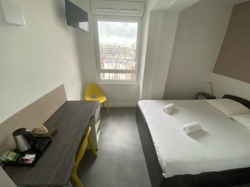 Cette chambre comprend un lit, un bureau et une fenêtre. dans l'établissement Moov'Appart Hotel Clichy, à Clichy