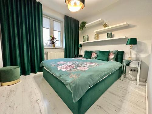 um quarto com uma cama verde e uma cortina verde em LuxApart Kalisz New em Kalisz