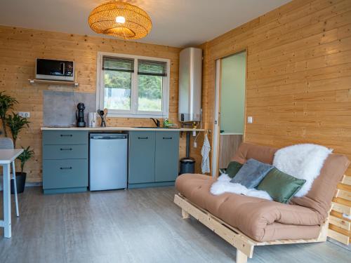un salon avec un canapé et une cuisine dans l'établissement Cottage 2 à 4 personnes ,au cœur des volcans, à Grandeyrolles
