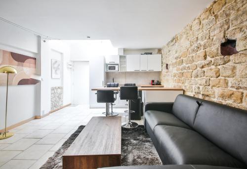 un salon avec un canapé et un mur de briques dans l'établissement 01#Duplex 4Pers#Sèvres-Lecourbe#Necker, à Paris