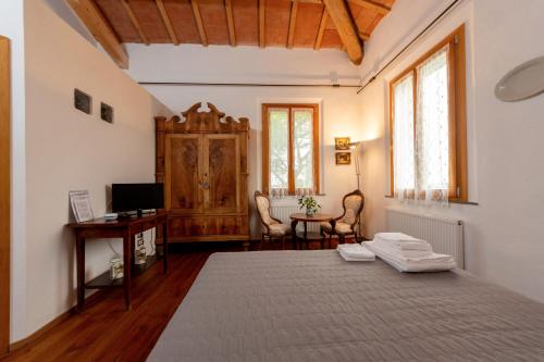 a bedroom with a bed and a desk and a television at Campanacci Agriturismo in Faenza