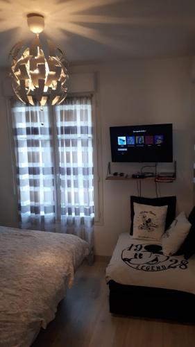 a bedroom with a bed and a chandelier at Le Charleston in Chessy